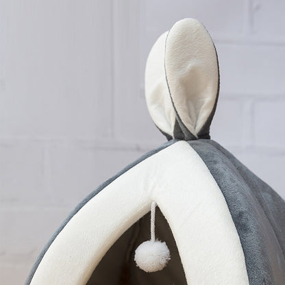 Cat curled up inside grey rabbit ear nest bed – cosy and secure